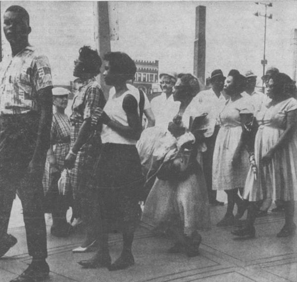 Black individuals stand together in a group outdoors